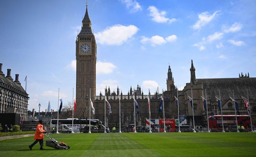 A groundsman puts the final touches to a pristine re-laid lawn at Parliament Square ahead of Kings Charles III coronation in London