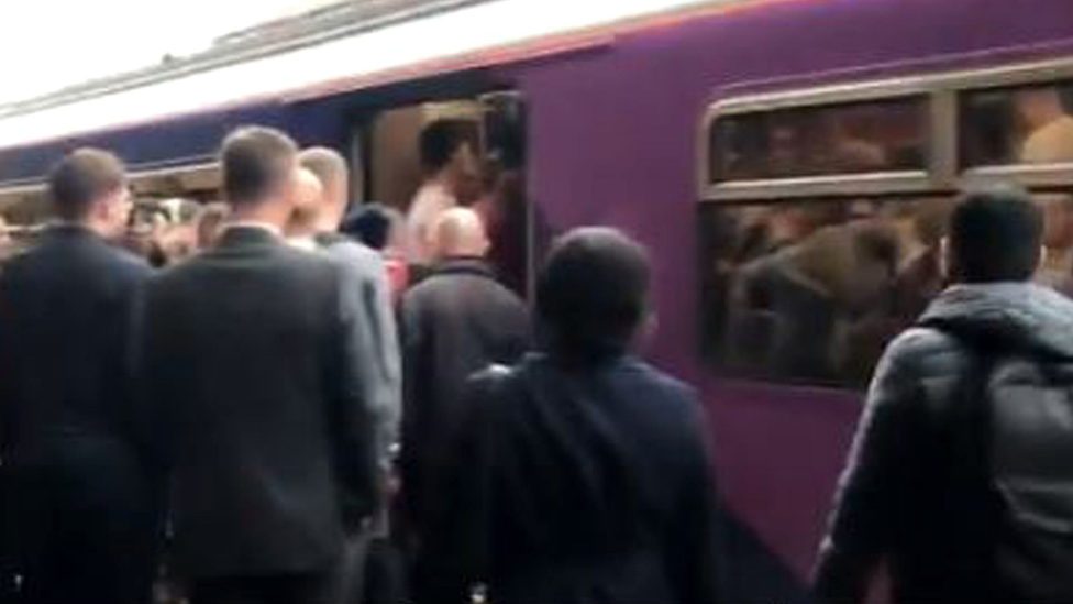 Commuters at Bolton train station trying to board a packed Northern Rail train