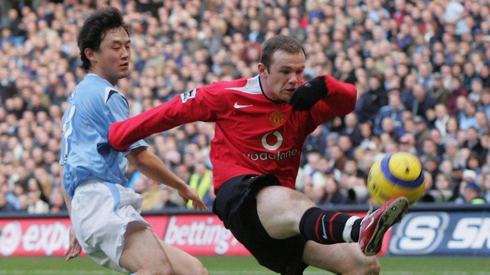 Manchester City's Jihai Sun challenges Manchester United's Wayne Rooney