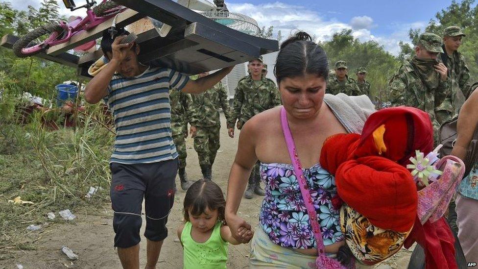 A Colombian woman cries as she arrives with her daughter in Cucuta after crossing the border on 26 August, 2015