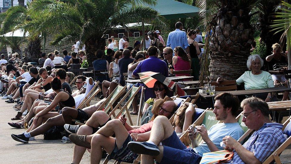 People relax at the Bode Museum along the Spree River during a sweltering summer day on July 4, 2015 in Berlin