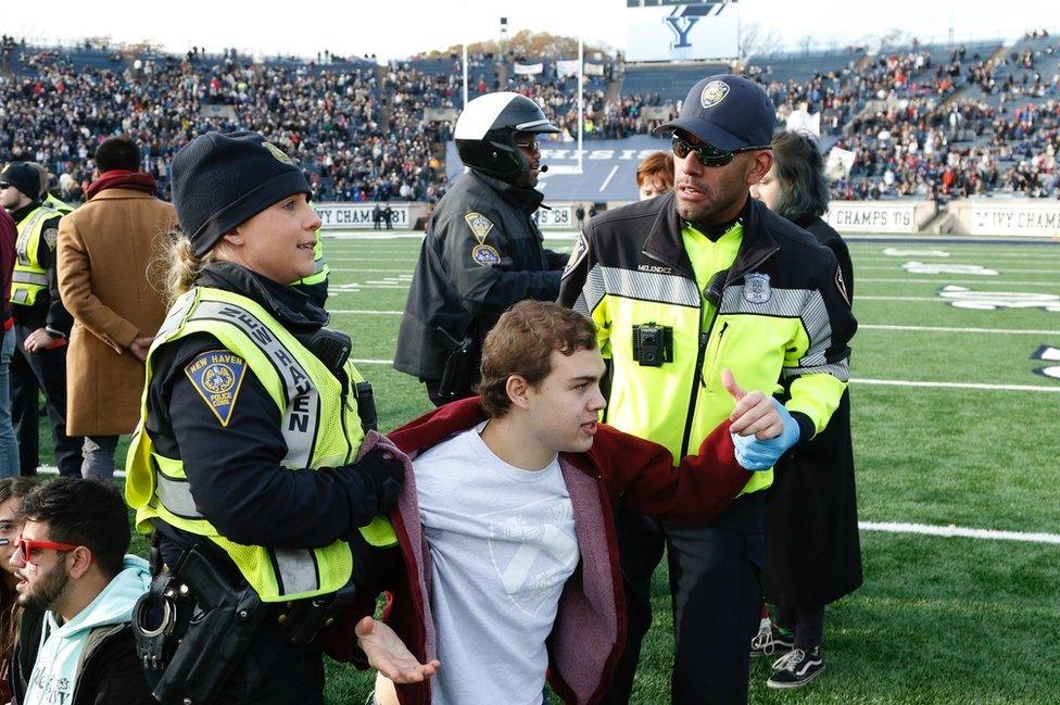 Police escort a protester from the field. 23 Nov 2019