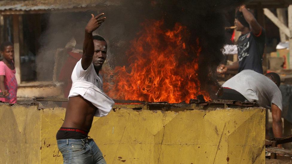 Man standing in front of a fire