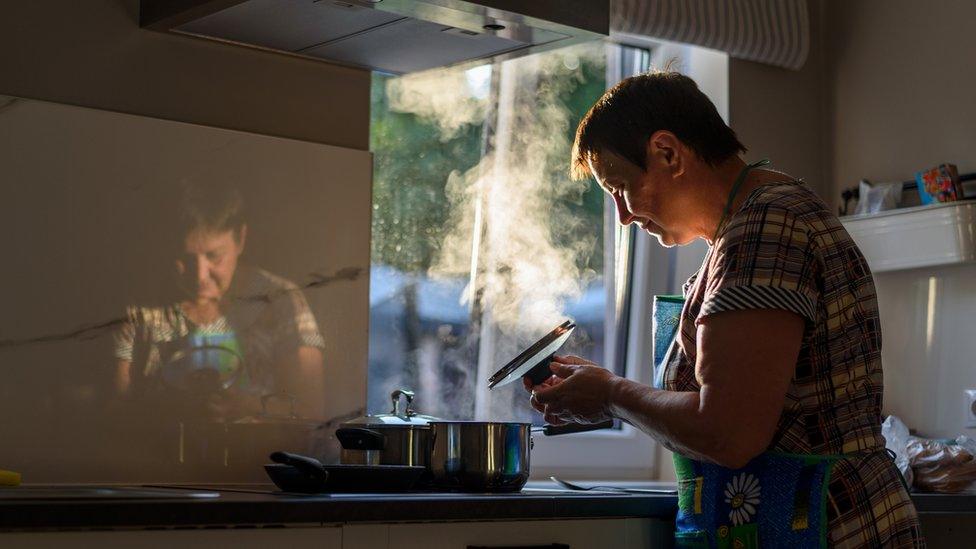 Older woman cooking on a stove