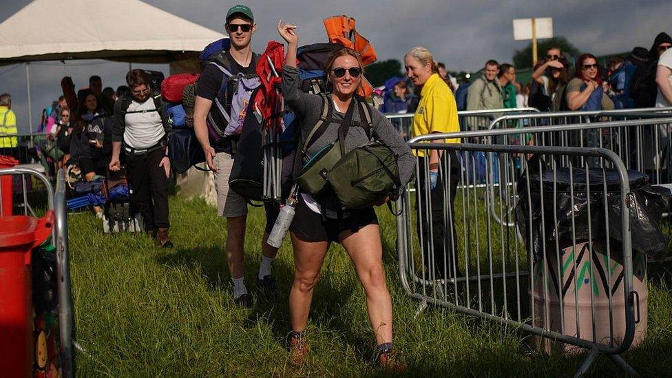 Man and woman entering Worthy Farm with bags