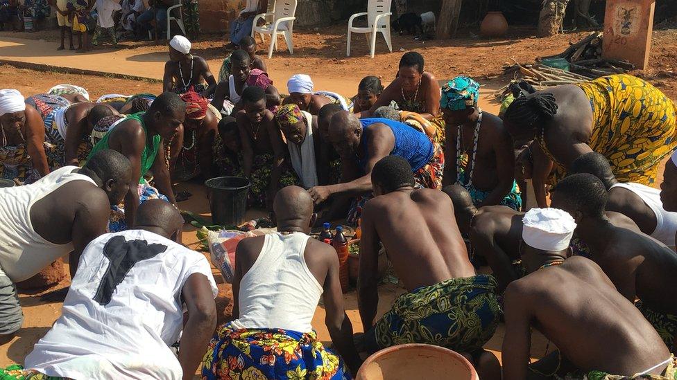 A group of voodoo followers pray during a cleansing ceremony in Ouidah, Benin