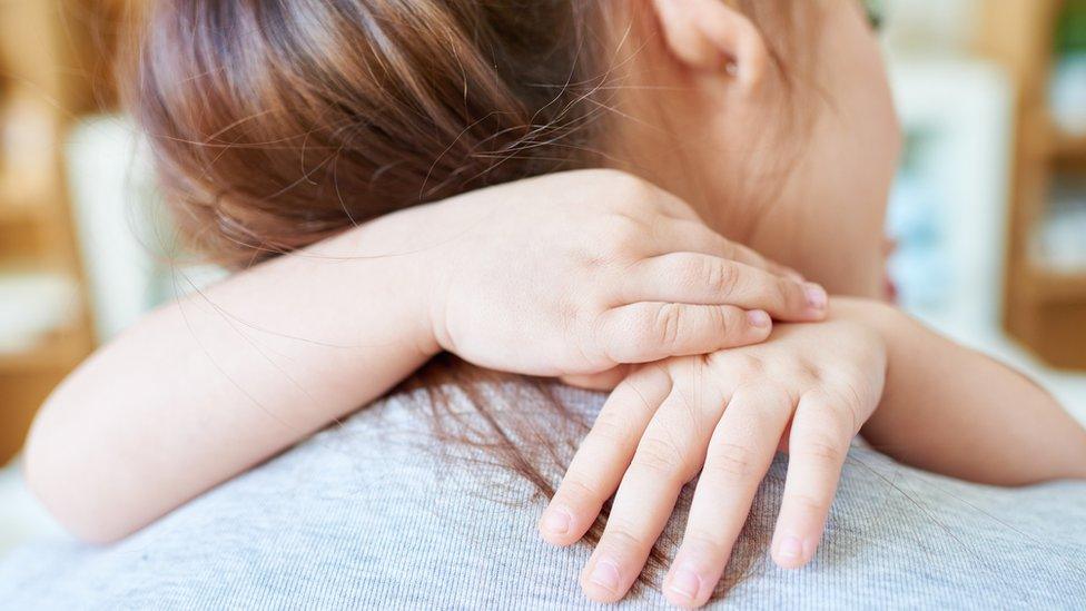 woman hugging child