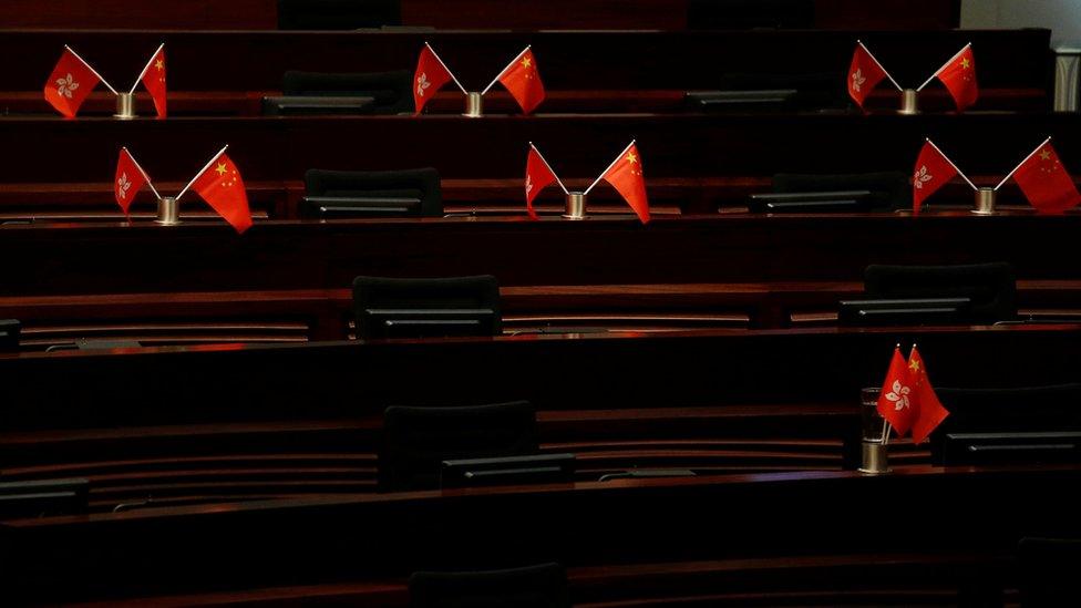 Empty seats with China and Hong Kong flags are seen inside a chamber after pro-Beijing lawmakers staged a walk-out