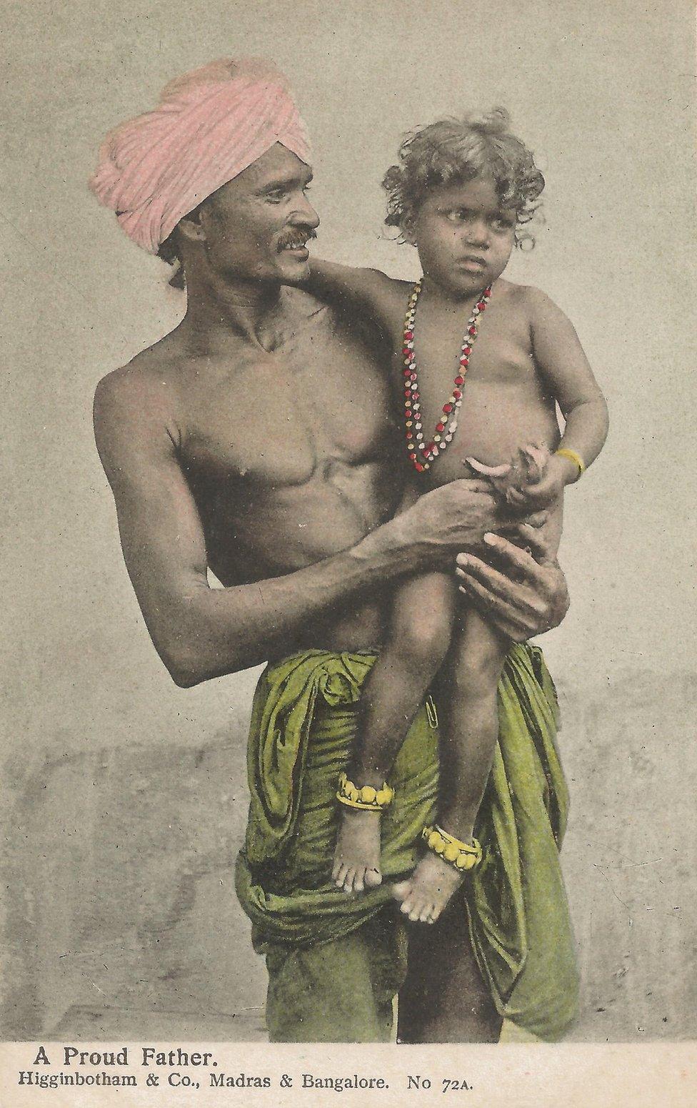 A turban-wearing Indian man holding his child