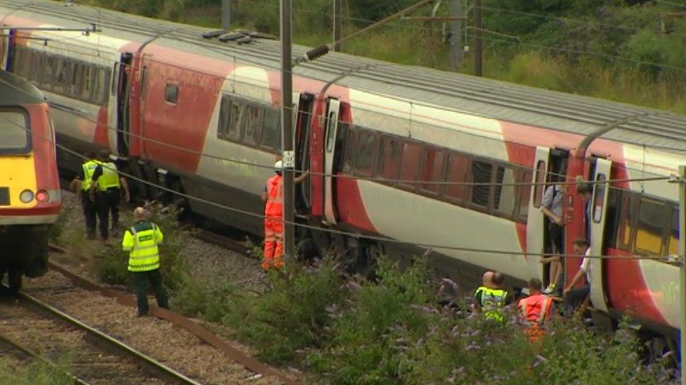 Passengers by open doors on stopped train