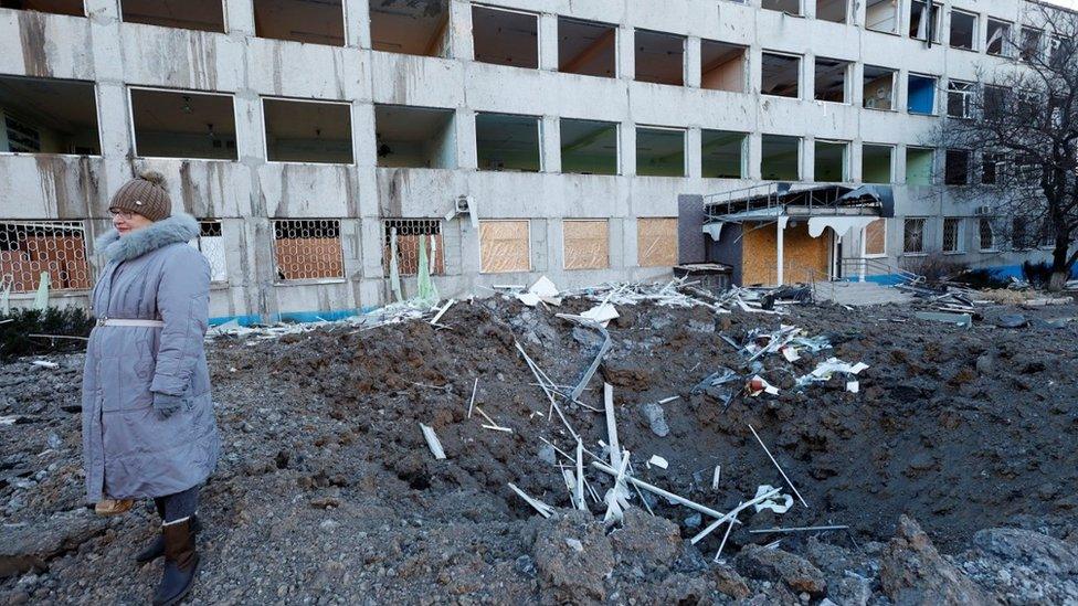 A woman stands at the site of a missile strike that occurred during the night in Kramatorsk