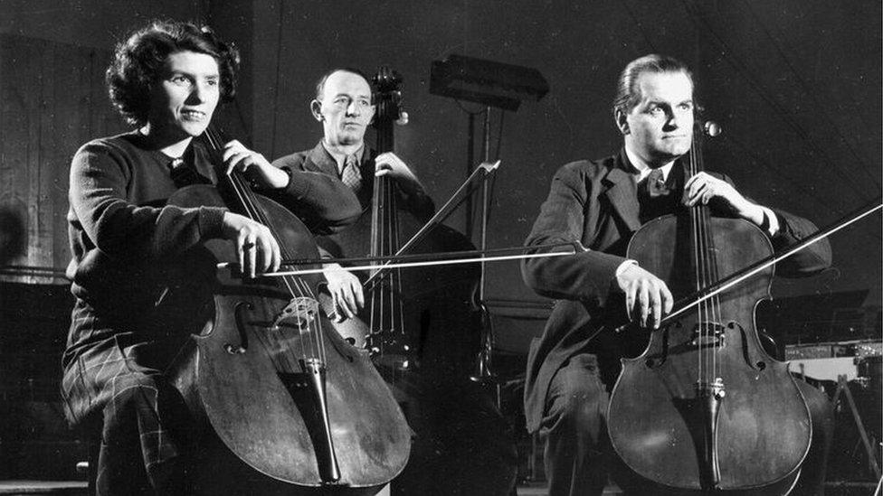 Cellist and double bassist posing for the camera in 1951