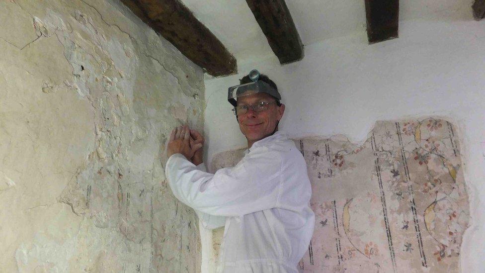 Peter Martindale working to restore the paintings