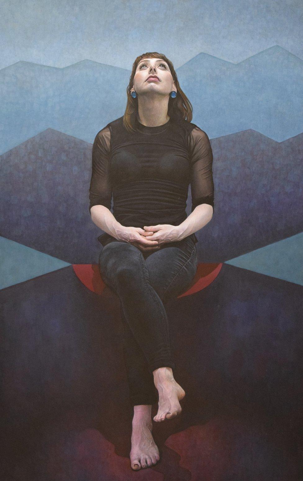 Portrait of a woman sat looking up with her legs crossed