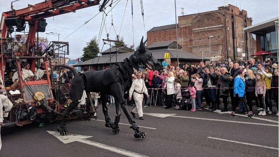 Xolo the Dog walks past crowds