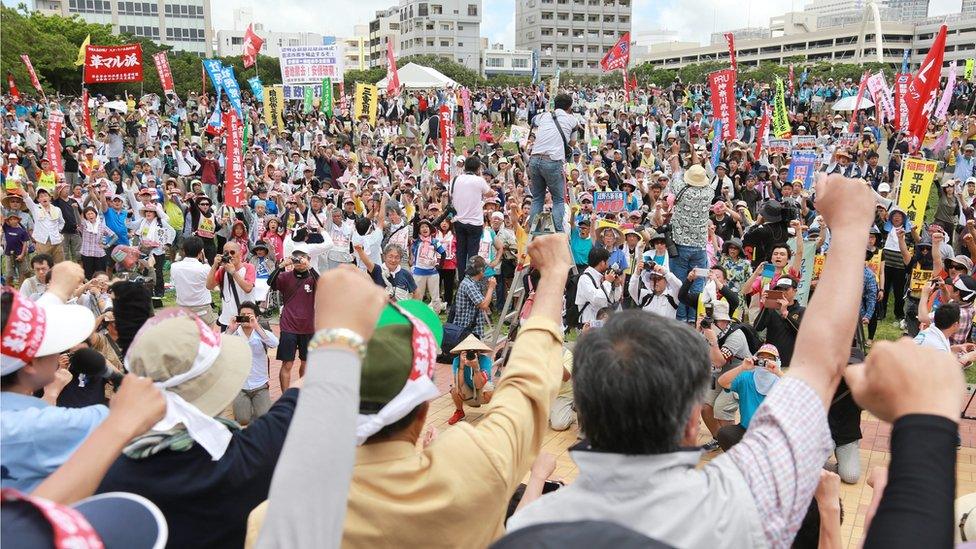 Hundreds of protesters shout slogans and raise fists during a demonstration in Naha on 15 May 2016 - the 44th anniversary of the islands' reversion from US control - against the construction of a US Marine Corps air base in Nago's Henoko district