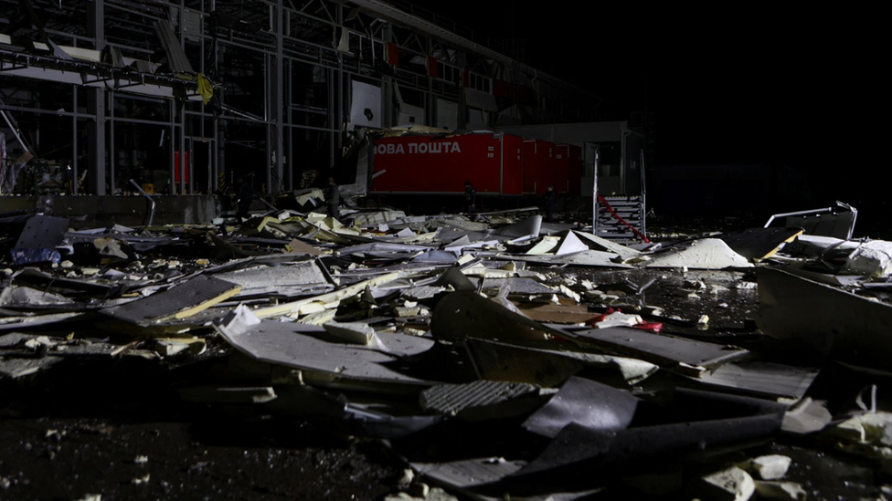 Police officers inspect a postal distribution centre of Nova Post company hit by Russian missiles, amid Russia's attack on Ukraine, in the village of Korotych