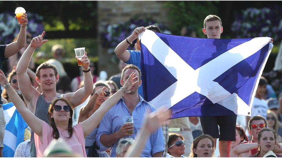 Fans of Andy Murray of Great Britain hold up a Scottish Saltire flag during his men's singles semi final match against Jerzy Janowicz of Poland on day eleven of the Wimbledon Lawn Tennis Championships at the All England Lawn Tennis and Croquet Club on July 5, 2013 in London, England