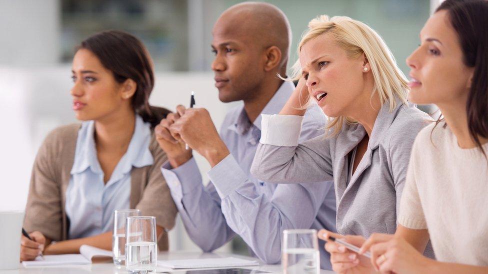 Businesswoman looking confused during a meeting with her colleagues