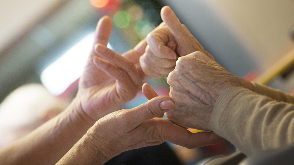 Patient and nurse holding hands