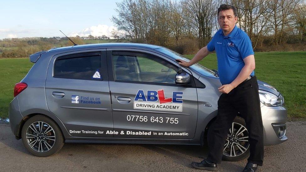 Eddie Ruskin standing by his car