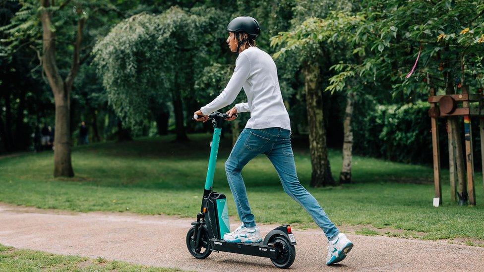 Man with a helmet riding an e-scooter