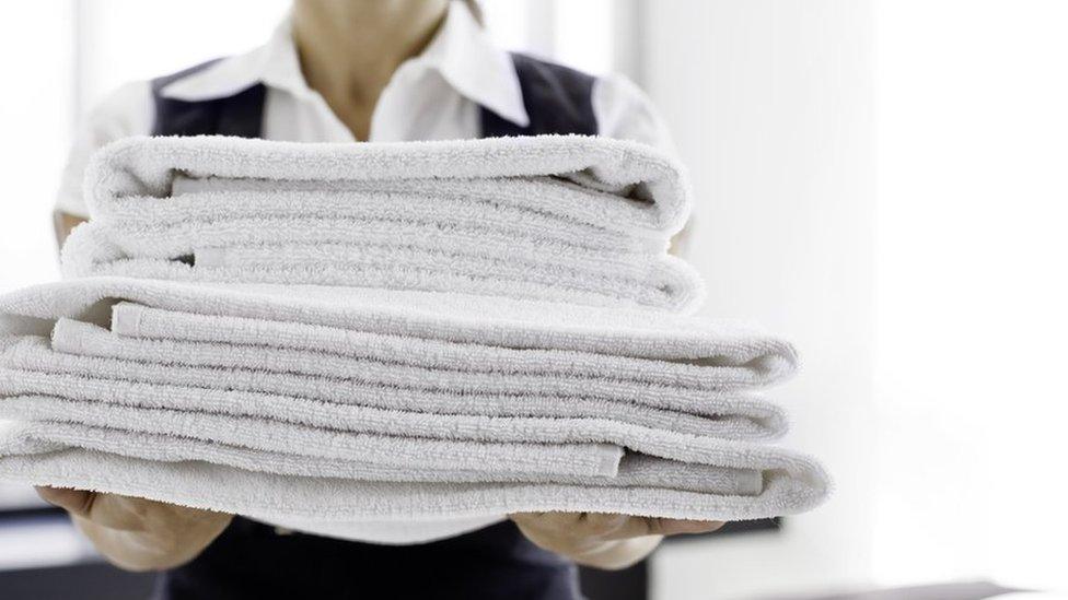 Stock image of a maid holding towels