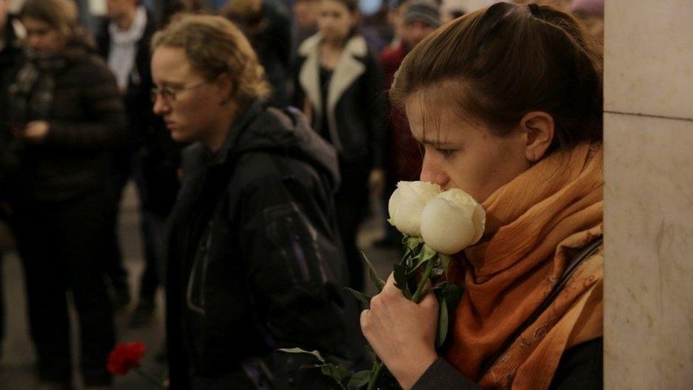 People hold flowers as they mourn the victims of a blast in St Petersburg metro at Tekhnologichesky institut station, April 4, 2017