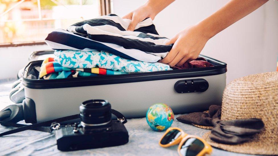 A person unpacking their bag at a hotel