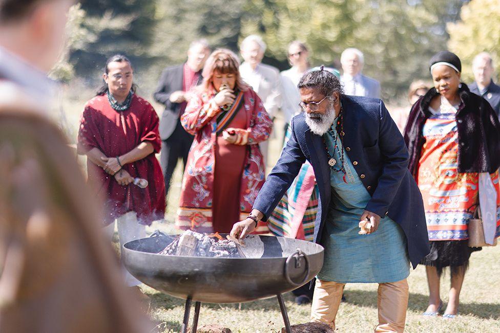 Delegates gather around a fire at the Harmony Summit in Highgrove