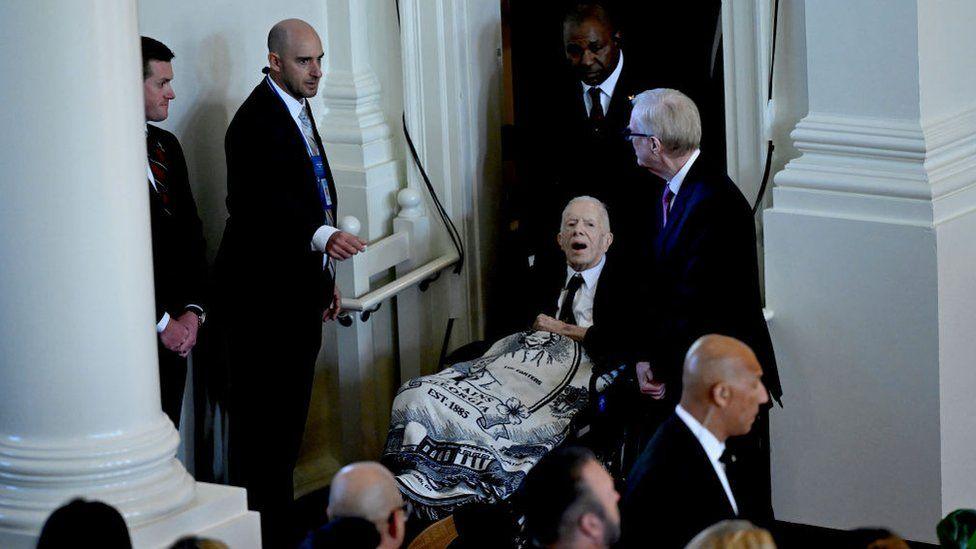 President Carter entering his wife's funeral service service 