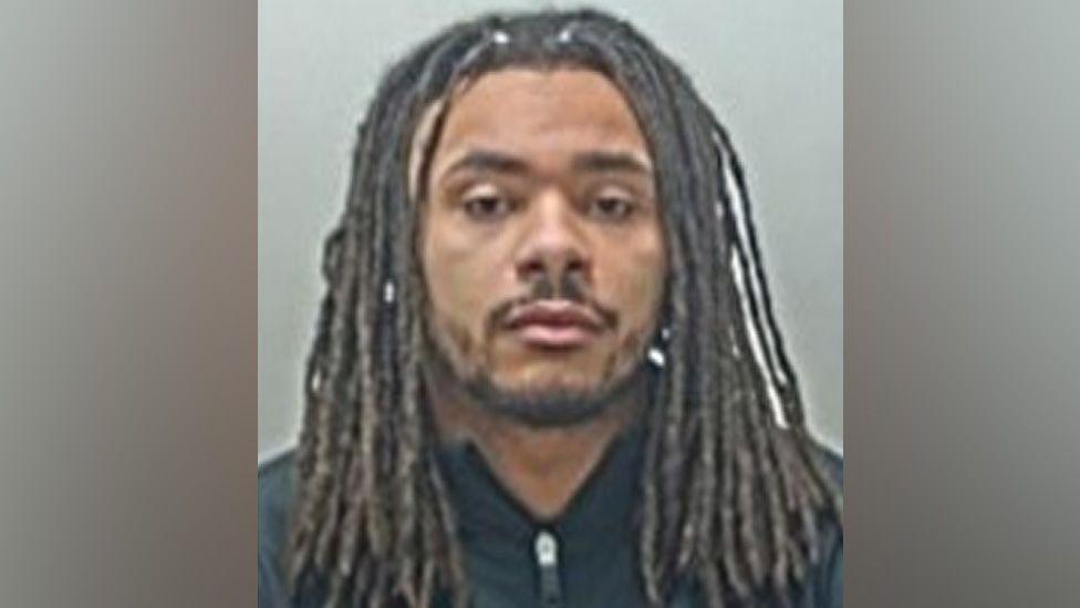 Andrew Phillips is staring directly at the camera and he has no expression on his face in his police mugshot.