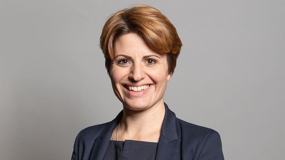 Emma Hardy MP she has brown short hair and is wearing a dark blue jacket and shirt