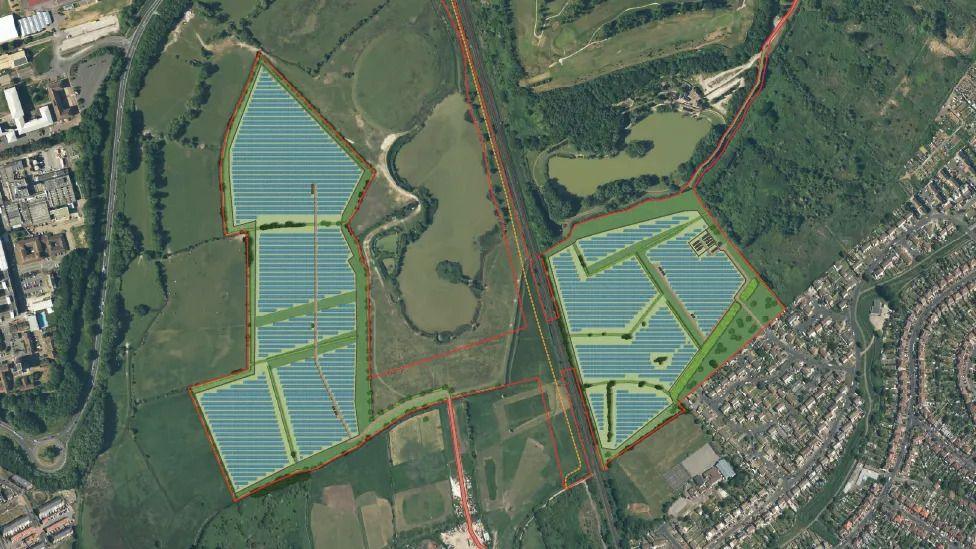 An aerial view of green field showing where two large plots of solar panels would be. The areas where they would be are shaded in blue