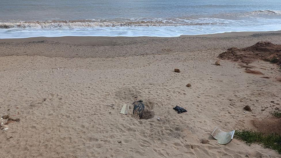 Hollym beach where the body was found there is a hole in the middle of the picture with a black blanket in it 