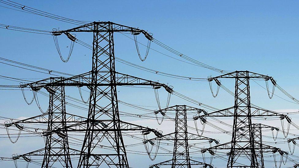 A view of electricity pylons against a blue sky