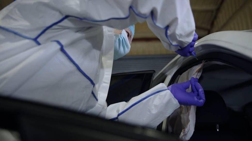 Ymchwilydd fforensig yn archwilio'r cerbyd