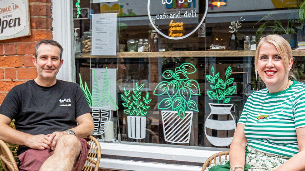 Paul and Claire sitting on the outside seating at their cafe 