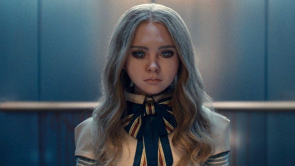 A doll with dressed with a bow and blank eyes