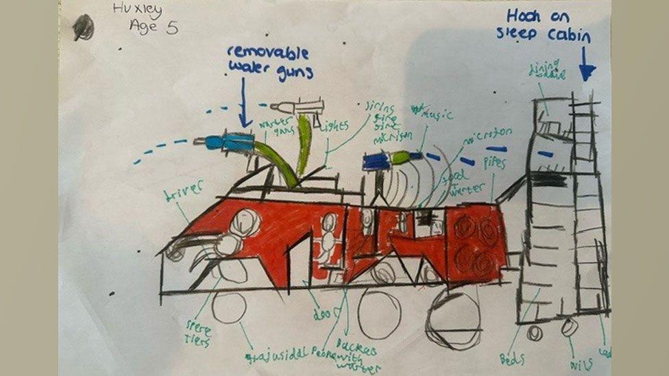 A drawing by Huxley aged five showing a futuristic fire engine, with a red body.  Around the drawing is writing pointing to the removable water guns, the lights, sirens and music.