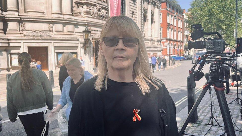 Nicola Jones stood on a London street wearing her Infected Blood victims pin