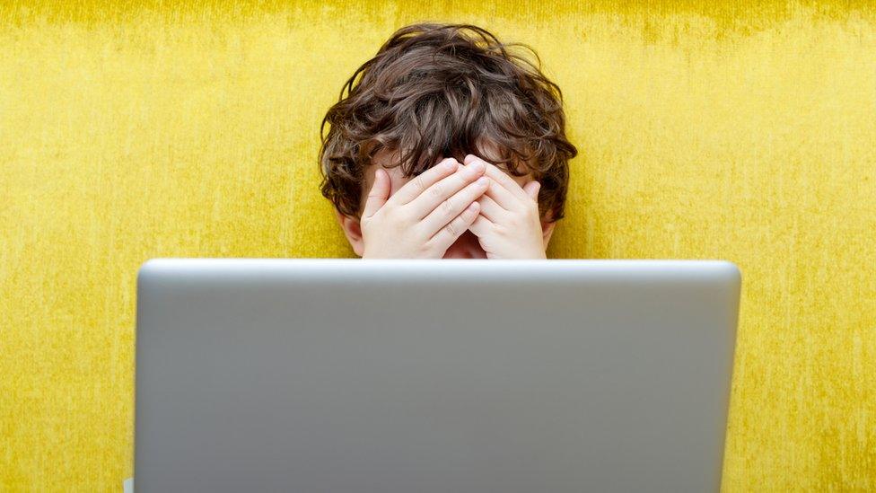 A scared child using a laptop