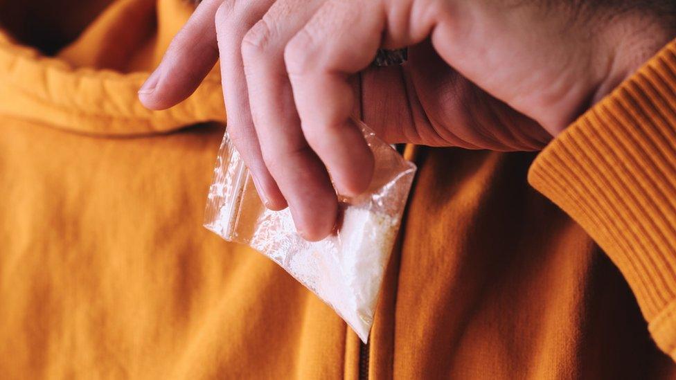 Man holding bag of cocaine