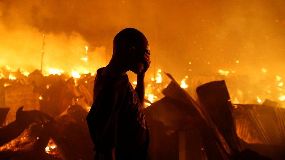 A resident reacts as he attempts to extinguish a fire that broke out at the Kijiji slums in the Southlands estate of Nairobi, Kenya, January 28, 2018