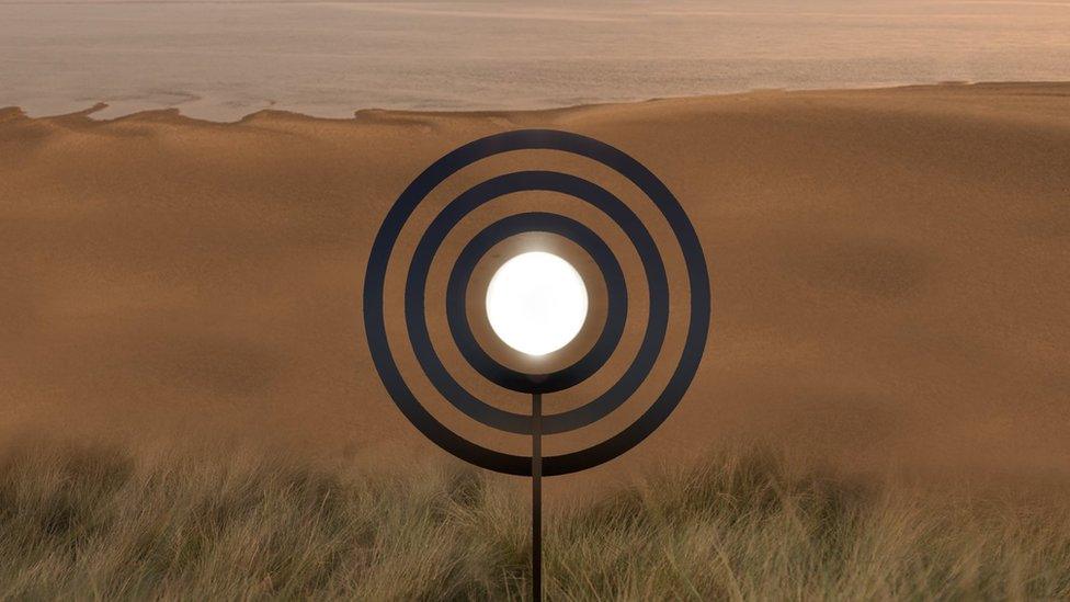 Three large concentric circles overlooking a beach with the pond shining white in the middle