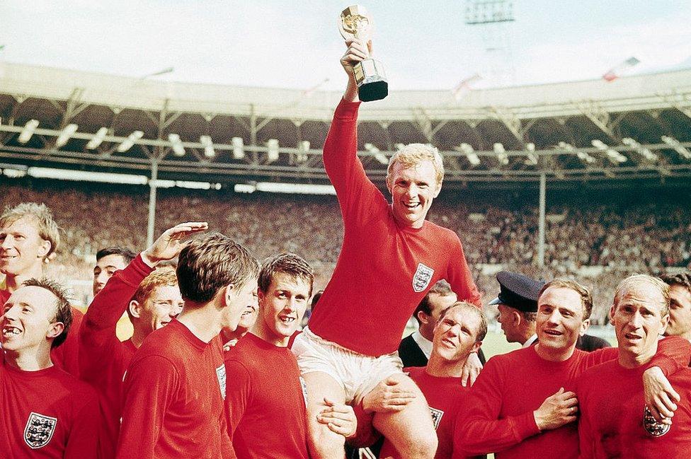 Bobby Moore holding the World Cup trophy aloft at Wembley as he is carried on the shoulders of his team-mates