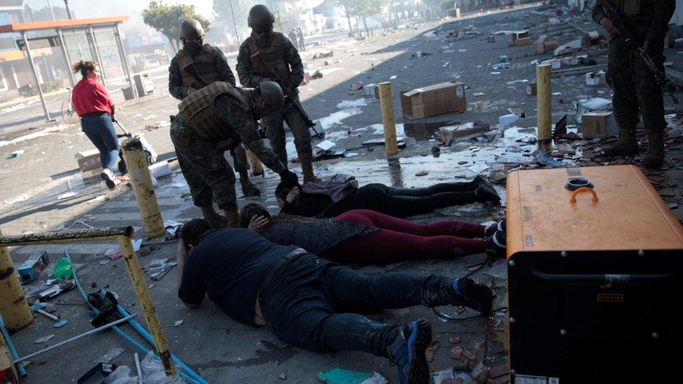 Security forces detain suspected looters during a protest against high living costs, in Concepcion, Chile October 21, 2019