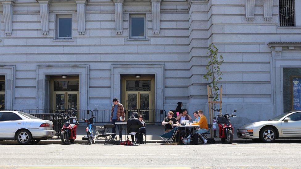 People work in a car parking space in San Francisco