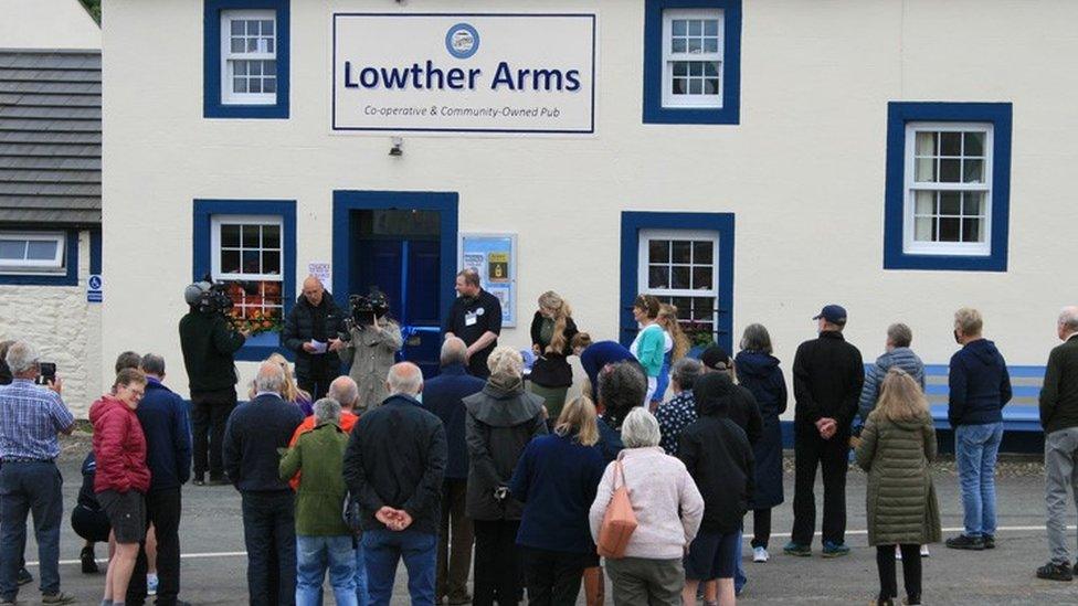 A crowd gather outside the pub for the reopening