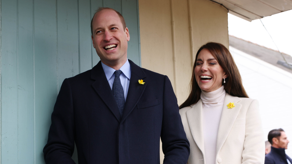 The royal couple laughing together during their visit